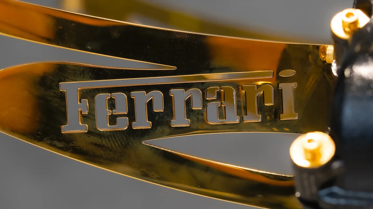 Signature Ferrari gravée sur le bras doré de la table