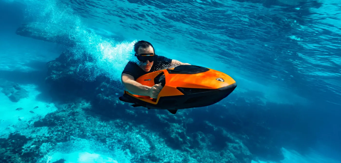 Pilote évoluant sous l'eau sur un SEABOB SE63 orange Arancio Egon